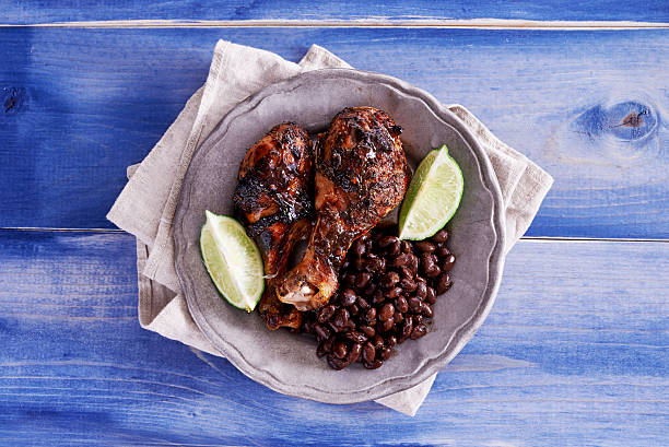 grilled jamaican jerk chicken with black beans shot top down grilled jamaican jerk chicken with black beans shot top down on wooden table painted blue caribbean culture stock pictures, royalty-free photos & images