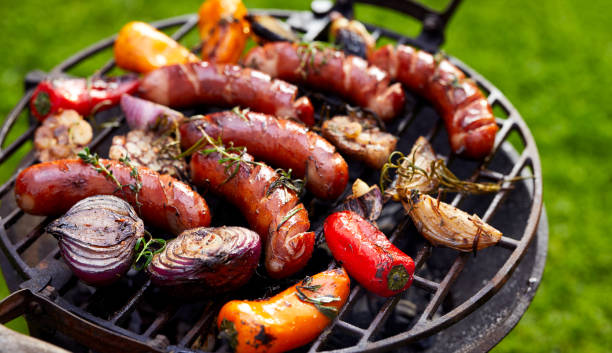 Grilled sausages and vegetables on a grilled plate, outdoor. stock photo