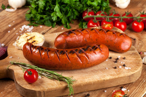 Grilled sausages on wooden background stock photo