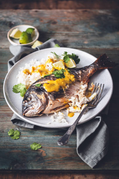 Grilled sea bream at Thai Yellow Curry Sauce stock photo