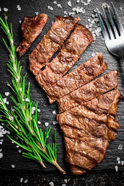 Grilled steak with a sprig of rosemary. stock photo