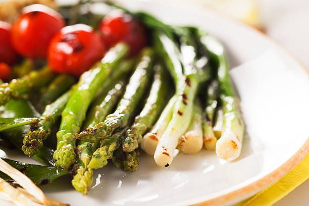 grilled vegetables - asparagus, onions, peas, tomatoes stock photo