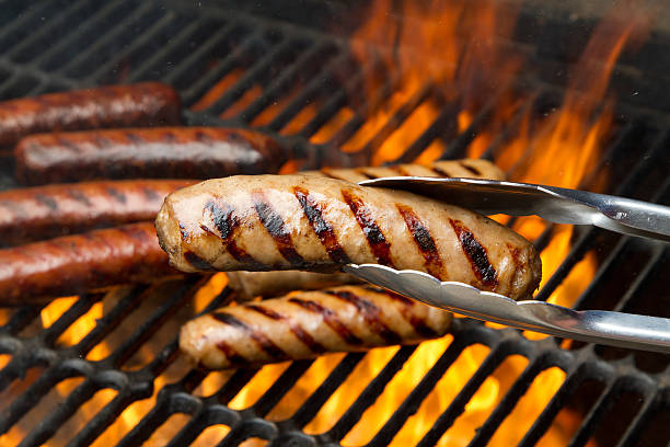 Grilling Brats Bratwurst on a flaming grill sausage stock pictures, royalty-free photos & images