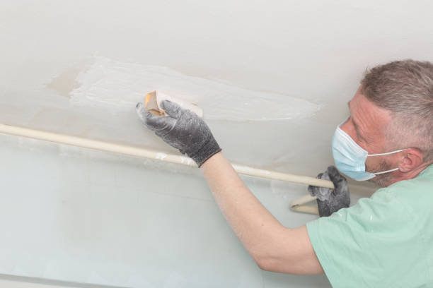 Grinding house ceiling Adult man worker repairing ceiling before painting ceiling cleaning stock pictures, royalty-free photos & images