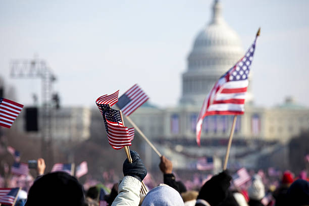A grip of people holding flags in front of the White House The inauguration of President Barack Obama, January 20th 2009.  Unrecognizable crowds in the Washington Mall.     2009 stock pictures, royalty-free photos & images