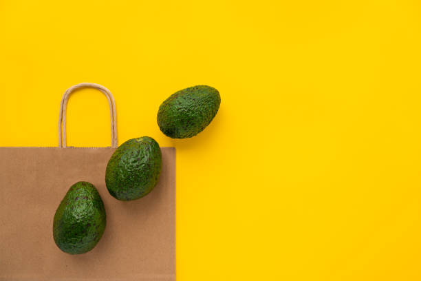 Grocery eco brown paper bag with avocados.Vegetarianism. Eco friendly shopping and health lifestyle concept. Flat lay stock photo