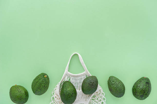 Grocery eco mesh cotton bag with avocados.Vegetarianism. Eco friendly shopping and health lifestyle concept. Space for text stock photo