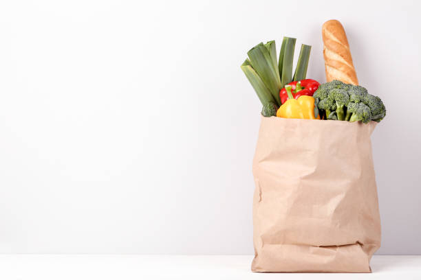 Grocery shopping bag with food on gray background stock photo