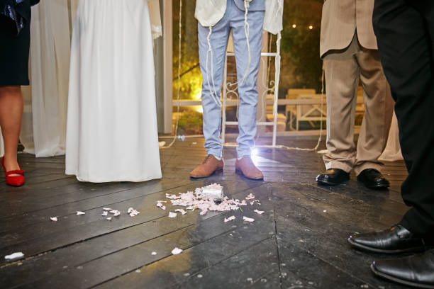 Groom breaking a glass at a Jewish wedding Groom breaking a glass at a Jewish wedding stamping it underfoot symbolizing the destruction of the temple in Jerusalem, close up of the right foot chupah stock pictures, royalty-free photos & images