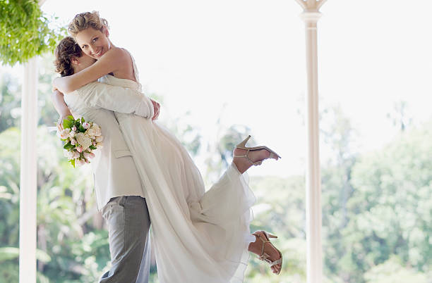 groom hugging and lifting bride - bride bildbanksfoton och bilder
