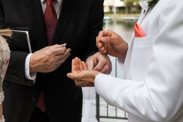 Groom Taking Ring From Pastor On Ceremony On Wedding Day stock photo
