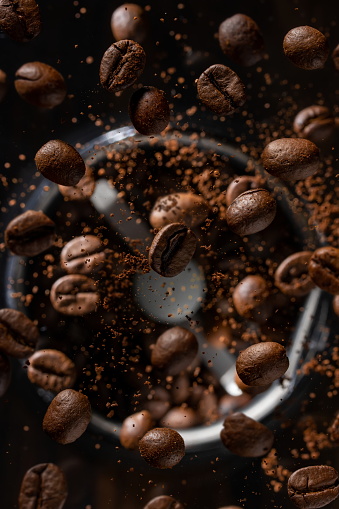 Ground coffee beans flying from a coffee grinder