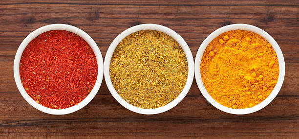 Ground condiments Three bowls containing ground spices (paprika, curry and turmeric) curry powder stock pictures, royalty-free photos & images