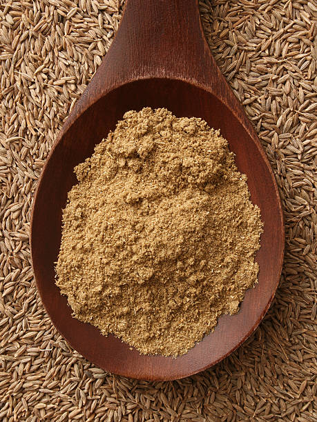 Ground cumin Top view of wooden spoon with ground cumin on it cumin stock pictures, royalty-free photos & images