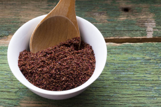 Ground sumac spice in white bowl, traditional Arabic ingredient for oriental food stock photo