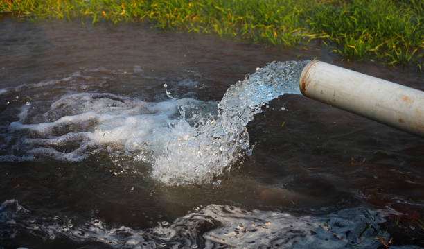 Ground Water Pump pumped into irrigation canal stock photo