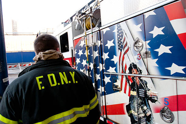 FDNY Ground Zero Fire Department New York City, New York, United States - February 25th, 2006: A New York Fireman standing at Engine Company 10 and Ladder Company 10, as one of their fire engines goes out on an emergency call. september 11 2001 attacks stock pictures, royalty-free photos & images