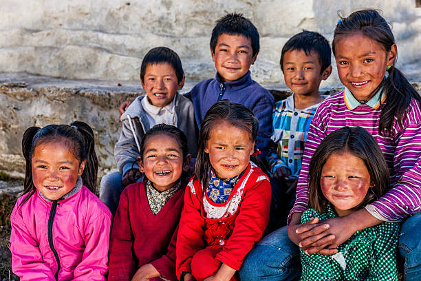Group happy Sherpa children in Everest Region Sherpa are an ethnic group from Khumbu - the most mountainous region of Nepal, high in the Himalayas. Many of them live inside Mount Everest National Park - the highest national park in the world, with the entire park located above 3,000 m ( 9,700 ft). This park includes three peaks higher than 8,000 m, including Mt Everest. Therefore, most of the park area is very rugged and steep, with its terrain cut by deep rivers and glaciers. Unlike other parks in the plain areas, this park can be divided into four climate zones because of the rising altitude. tibetan ethnicity stock pictures, royalty-free photos & images