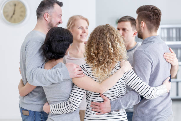 Group hug during therapy People having group hug during therapy in rehab drug rehab stock pictures, royalty-free photos & images