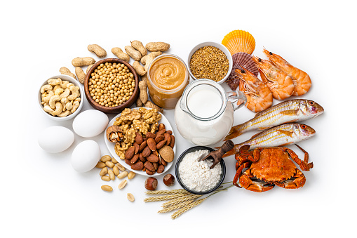 Group of allergy foods isolated on white background. The composition includes soy beans, eggs, dairy products, nuts, seafood an wheat.
