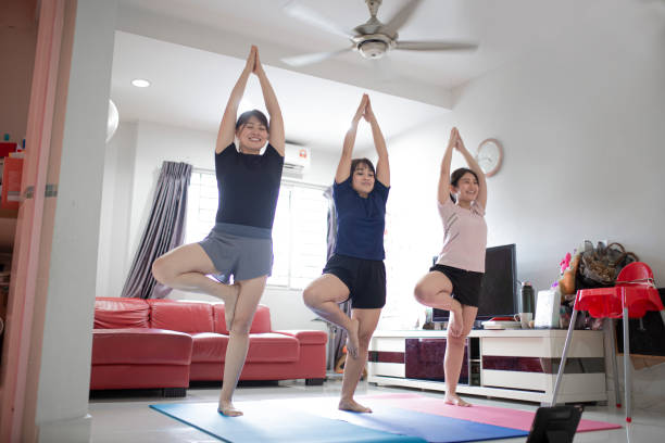 Group of Asia Chinese female friends having exercise training in domestic living room together using laptop for online class  asian yoga pants stock pictures, royalty-free photos & images