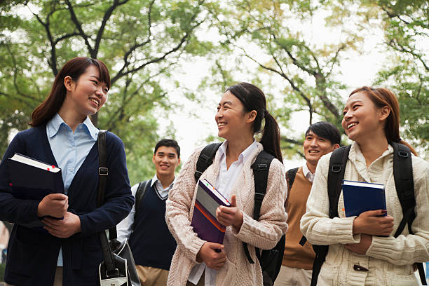 Group of Asian university students on campus with books stock photo