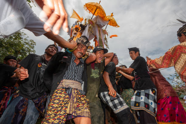 A group of Balinese people is carrying Balinese statue on their shoulders and heading to the cremation ceremony location. stock photo