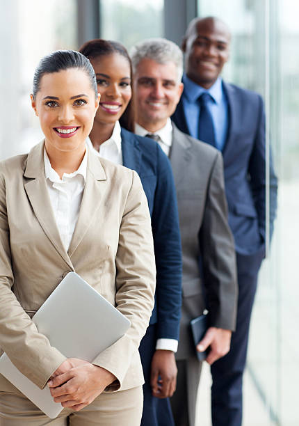 group of business executives standing in a row group of happy business executives standing in a row waiting in line photos stock pictures, royalty-free photos & images