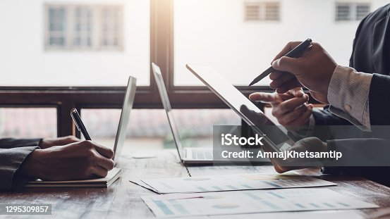 istock Group of business people meeting, discussing, analyzing graphs, financial data, and planning a marketing project together. 1295309857