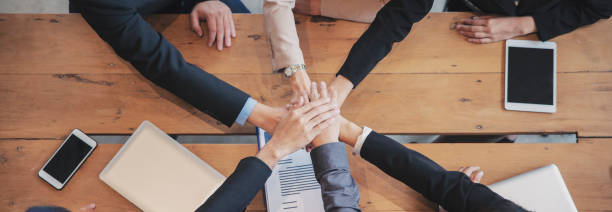 Group of businesspeople holding hand together after success work. Collaboration of Group of diversity business people plan strategy startup during brainstorming meeting with team-panoramic banner stock photo