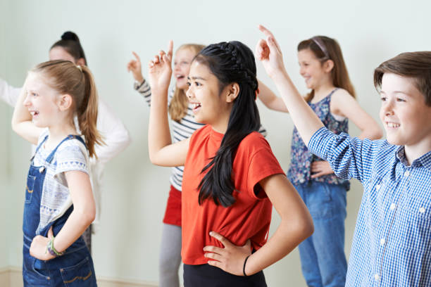Group Of Children Dancing In Drama Class Together Group Of Children Dancing In Drama Class Together acting performance stock pictures, royalty-free photos & images