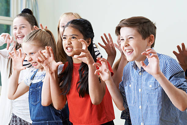 Group Of Children Enjoying Drama Club Together Group Of Children Enjoying Drama Club Together acting performance stock pictures, royalty-free photos & images