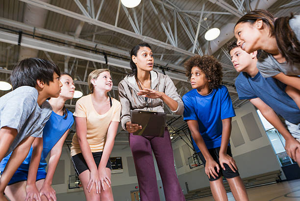 Group of children with coach in school gym Multi-ethnic group of children with coach in school gym. middle school teacher stock pictures, royalty-free photos & images