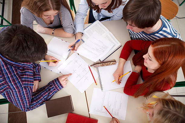 Group of college students studying together A cheerful group of university students are  writing students group stock pictures, royalty-free photos & images