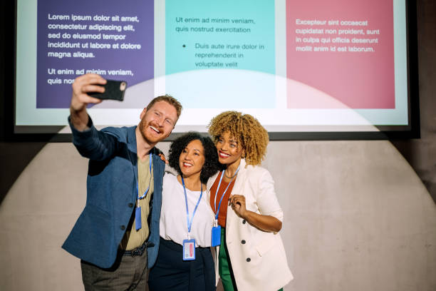 Group of conference presenters taking a selfie together stock photo
