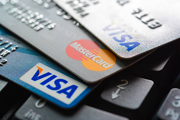 group of credit cards on computer keyboard - bankpas stockfoto's en -beelden