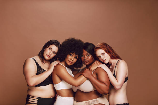 Group of different size women in lingerie Group of different size women in lingerie looking at camera with proud. Multiracial women in different under garments posing together. body positive stock pictures, royalty-free photos & images