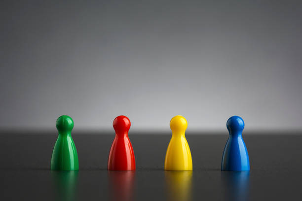 Group of four figurines in different colors in a row stock photo