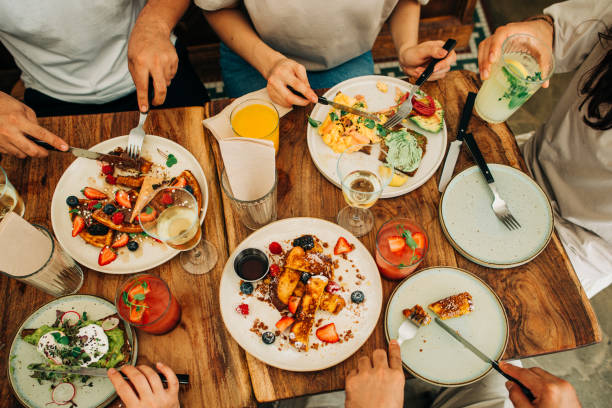 Group of friends eating breakfast or brunch in restaurant stock photo