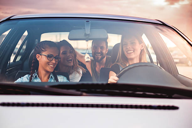 Group of friends having fun in the car stock photo