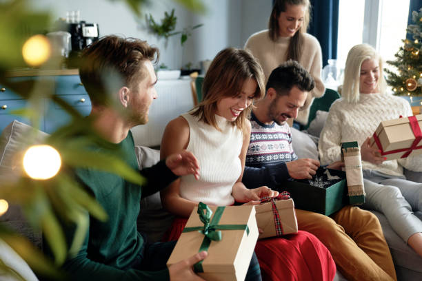 Group of friends opening Christmas presents stock photo