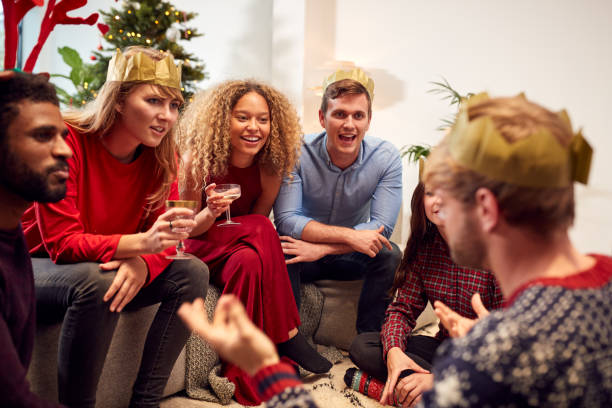Group Of Friends Playing Charades After Enjoying Christmas Dinner At Home Group Of Friends Playing Charades After Enjoying Christmas Dinner At Home charades stock pictures, royalty-free photos & images