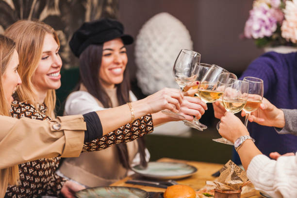 Group of friends toast with wine at restaurant stock photo