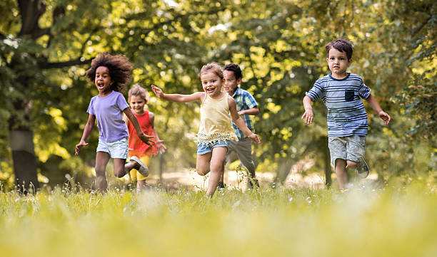 Group of happy children having fun while running in nature. stock photo
