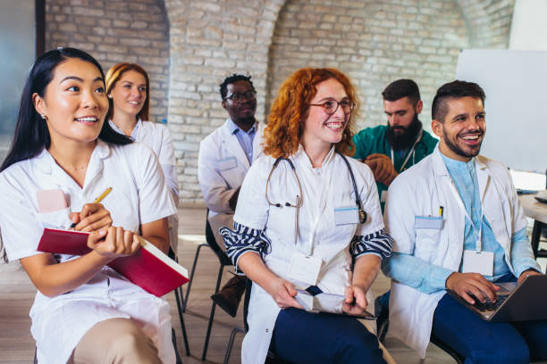 Group of happy doctors on seminar in lecture hall at hospital Group of happy doctors on seminar in lecture hall at hospital medical schools stock pictures, royalty-free photos & images