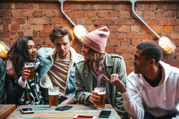 Group of happy friends having fun in a pub drinking ice cold beers stock photo