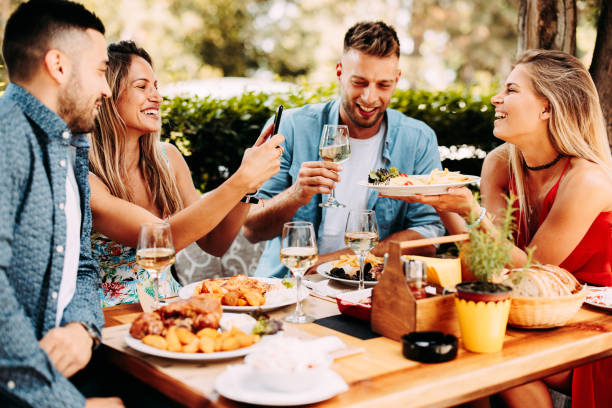 Group of Happy friends having lunch in the restaurant during a sunny summer day stock photo