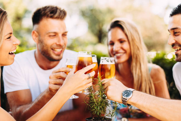 Group of happy friends toasting with beer. Selective focus on beer stock photo