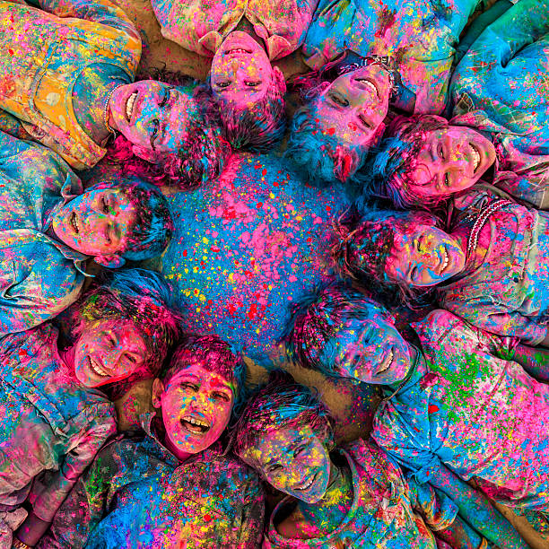Group of happy Indian children playing holi, desert village, India Group of happy Gypsy Indian children playing happy holi on sand dunes in desert village, Thar Desert, Rajasthan, India. Children are lying in a circle. Color powders are on their faces and clothes. Holi is a religious festival in India, celebrated, with the color powders, during the spring. holi photos stock pictures, royalty-free photos & images