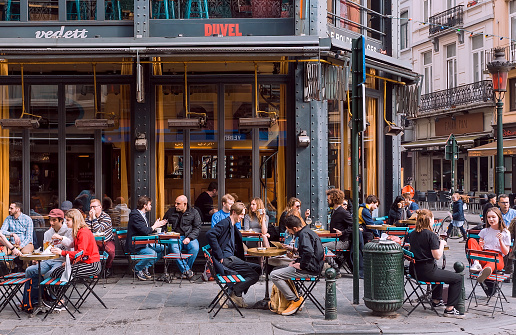 Brussels, Belgium: Group of happy people meeting at street cafe area for drinks at busy evening on April 9, 2018. More than 1,200,000 people lives in Brussels
